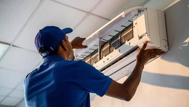 Technician working on a wall-mounted indoor air conditioner
